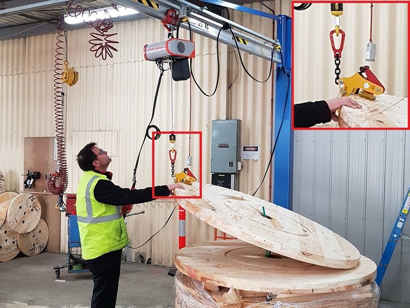 Jib crane with custom plate grab on hoist for round timber reel ends